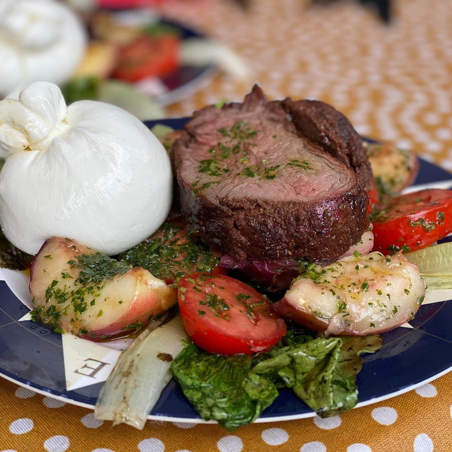 Bord met gegrilde nectarine, burrata en tomaat