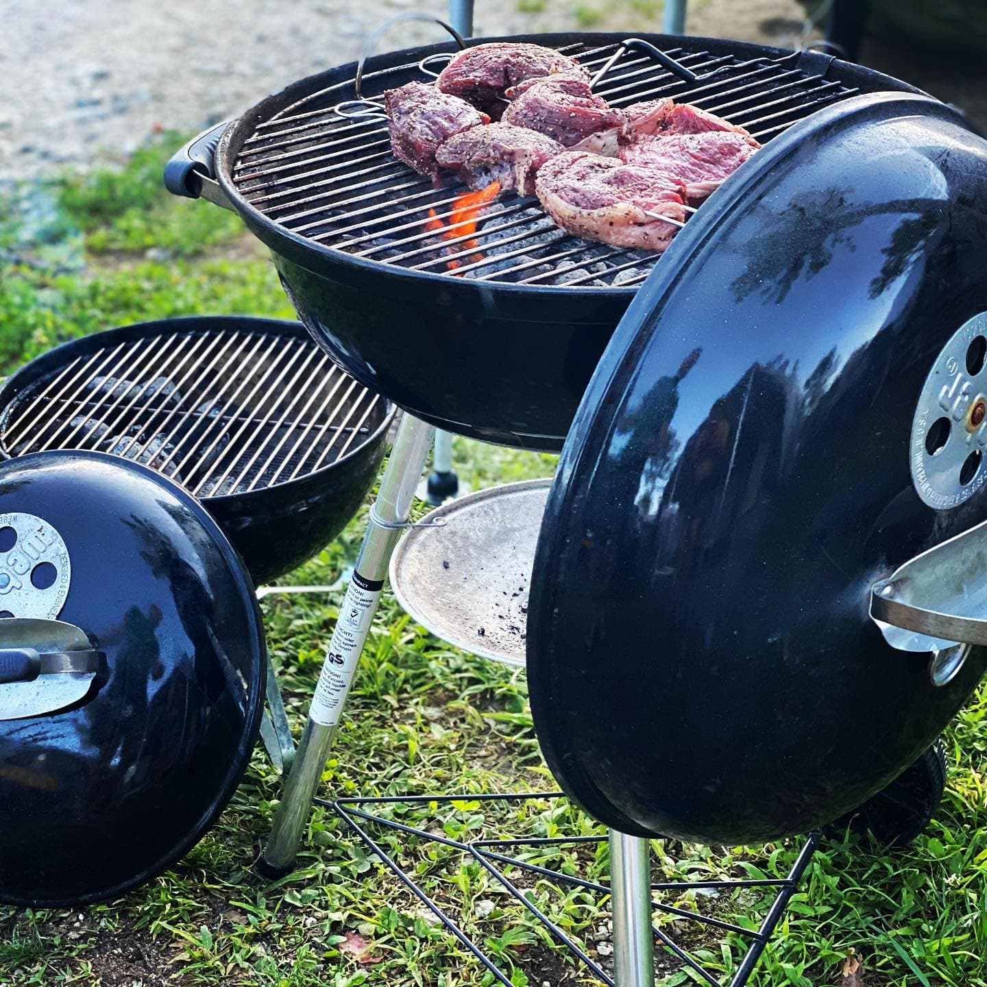 Twee kettles naast elkaar, steaks op het rooster