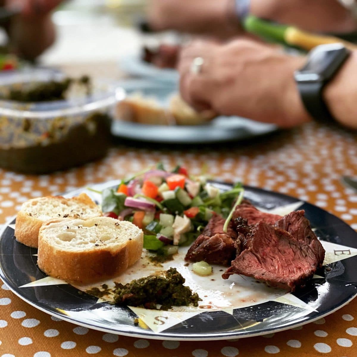 Rosé gesneden picanha met chimichurri en gegrild brood op het bord