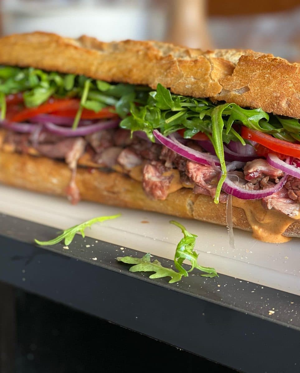 Baguette met steak, rucola, tomaat en rode ui